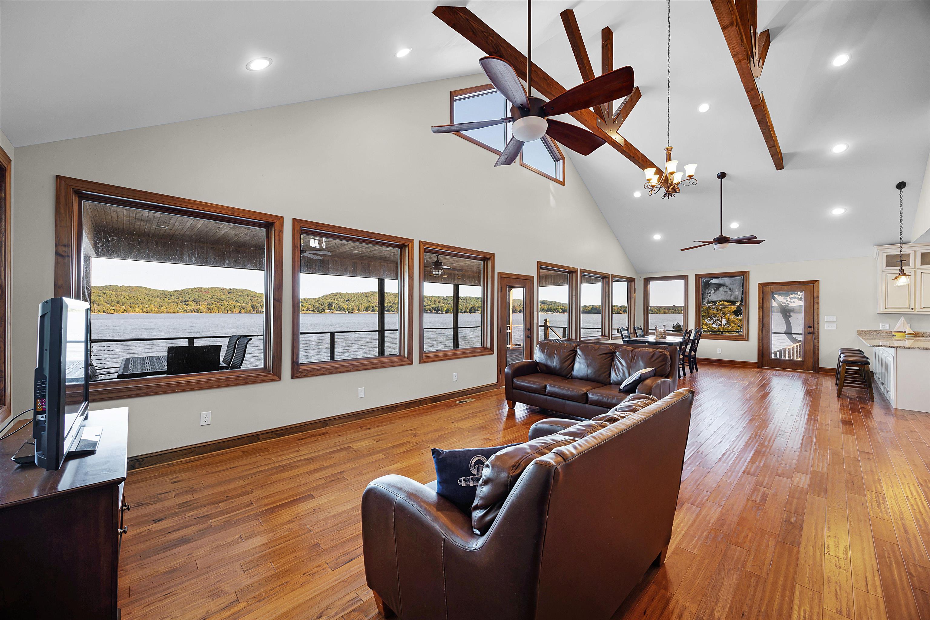 830 Big Bear Creek Road Cherokee, MS 35616 - Photo 8 of 39 Living room with ceiling fan with notable chandelier, light wood-type flooring, beam ceiling, and high vaulted ceiling
