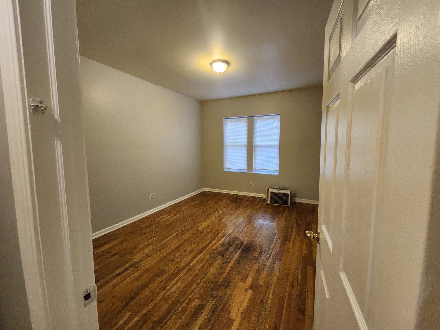 8016 South Ingleside Avenue, Unit 2S Chicago, IL 60619 - Photo 4 of 8 a view of empty room with wooden floor and fan