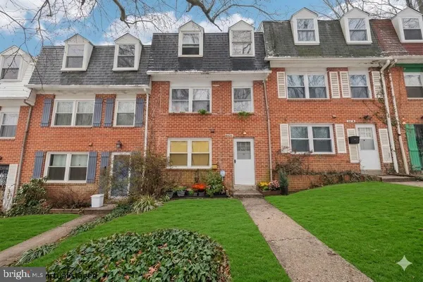 front view of a brick house with a yard
