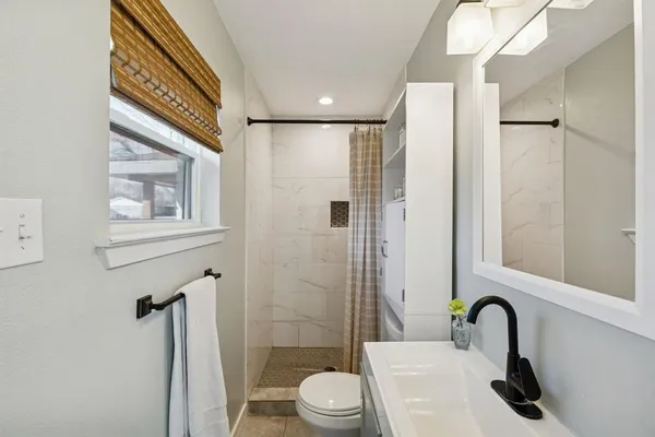 a bathroom with a sink toilet and a mirror