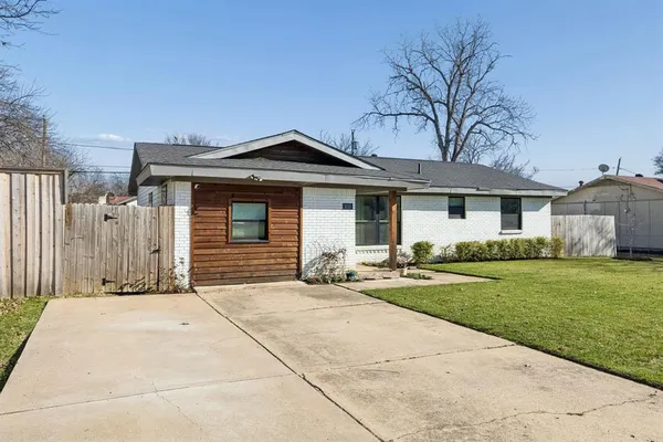 a front view of a house with a garden and yard