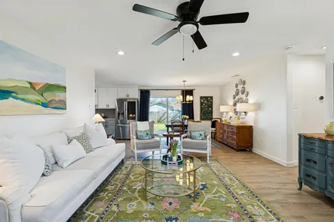 a living room with furniture and a view of kitchen