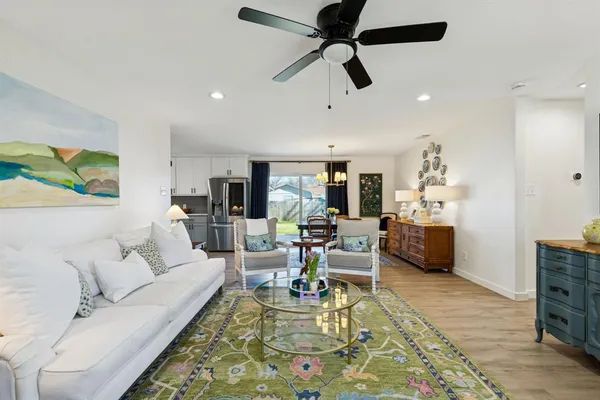 a living room with furniture and a view of kitchen