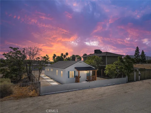 a front view of a house with a yard and mountain view