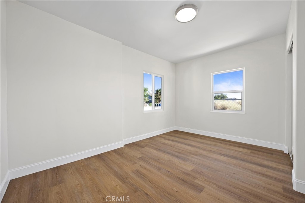 102 Jackson Street Taft, CA 93268 - Photo 16 of 34 an empty room with wooden floor and windows