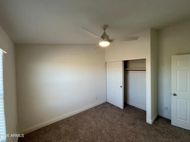 an empty room with a fan and a window