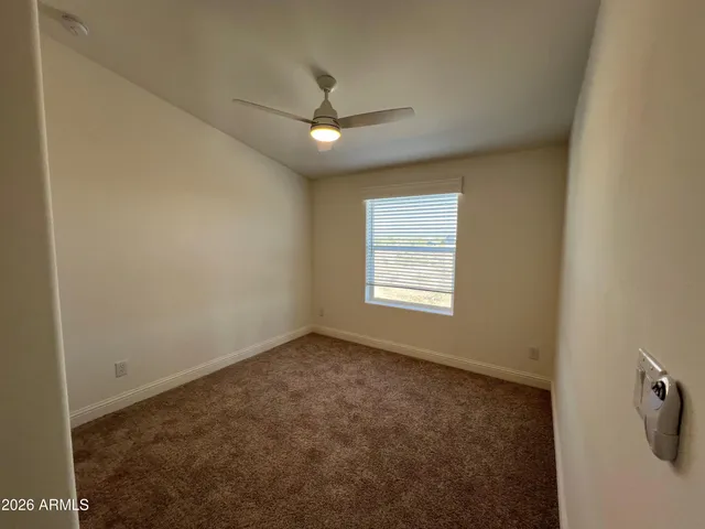 an empty room with a window and a fan