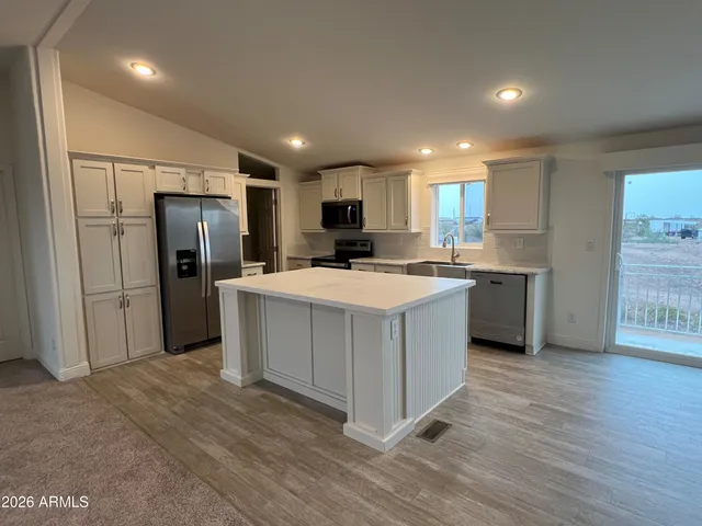 a kitchen with a refrigerator a sink and a microwave