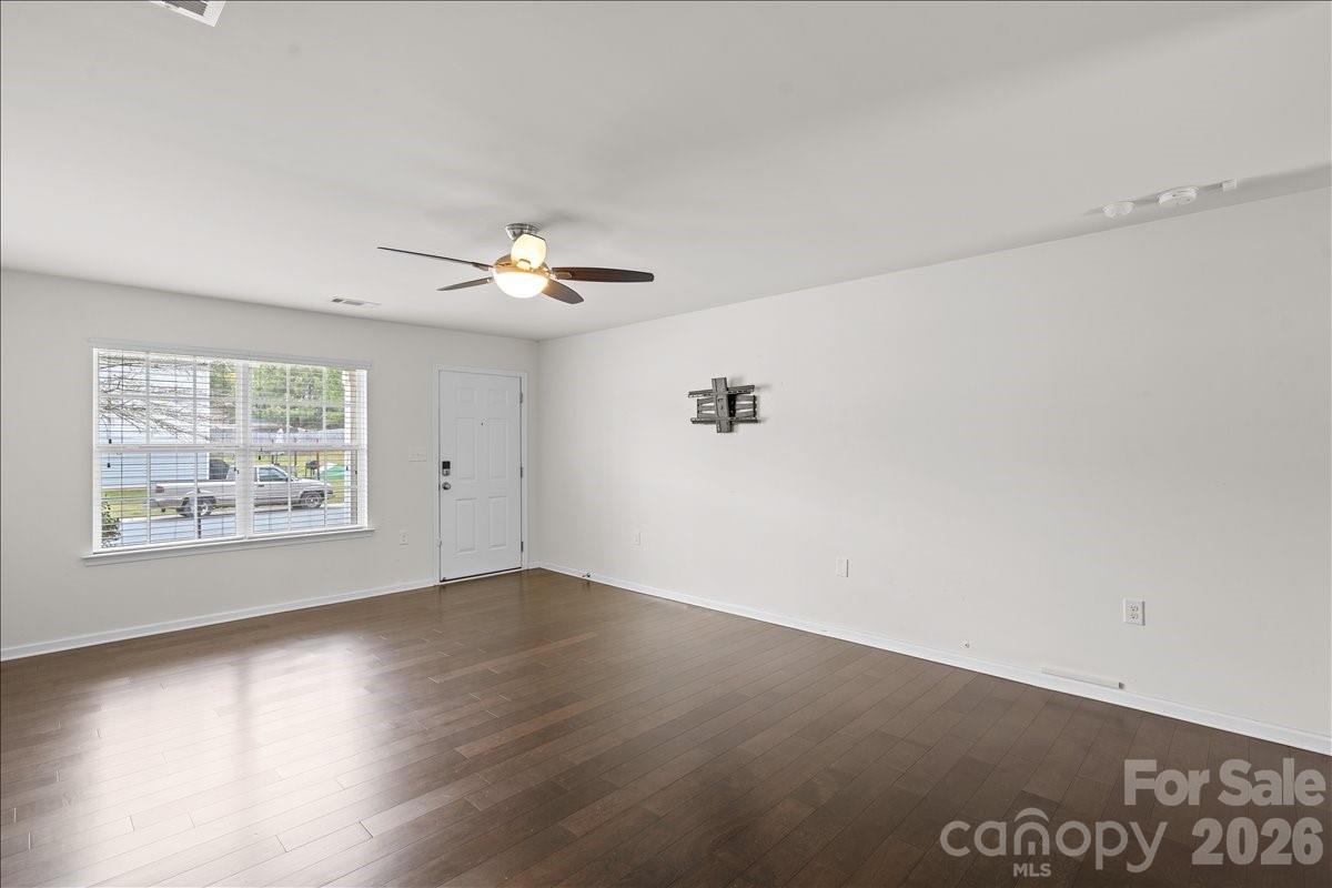 6066 Benedict Place, Unit 32 Fort Mill, SC 29707 - Photo 2 of 32 an empty room with wooden floor chandelier fan and windows