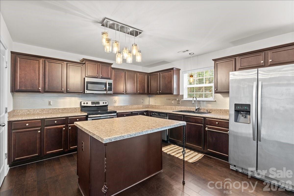6066 Benedict Place, Unit 32 Fort Mill, SC 29707 - Photo 7 of 32 a kitchen with stainless steel appliances granite countertop a stove top oven a sink dishwasher a refrigerator and cabinets with wooden floor