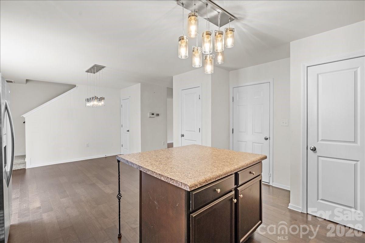 6066 Benedict Place, Unit 32 Fort Mill, SC 29707 - Photo 10 of 32 an empty room with kitchen view and wooden floor