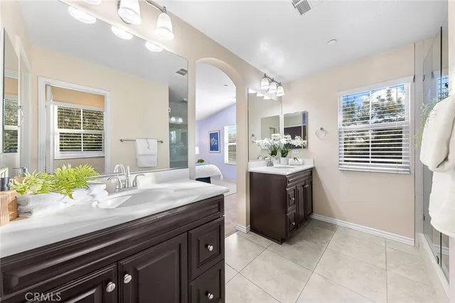 a spacious bathroom with a granite countertop sink a mirror and a bathtub