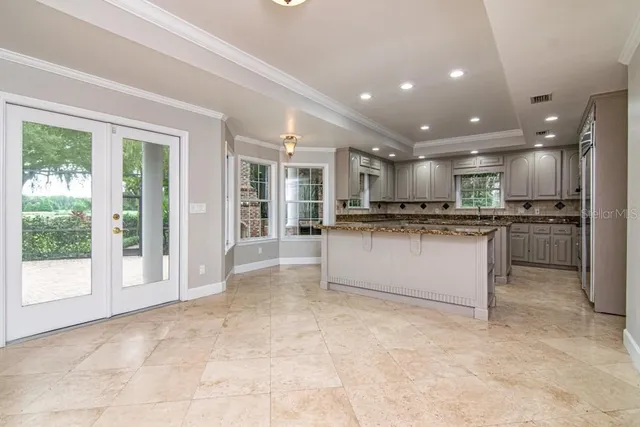 a kitchen with kitchen island granite countertop a stove sink and cabinets