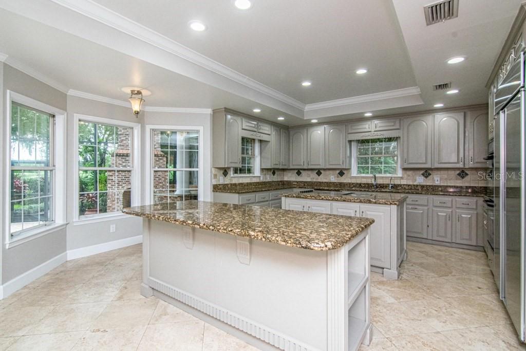 16405 Avila Boulevard Tampa, FL 33613 - Photo 18 of 61 a kitchen with kitchen island granite countertop a stove sink and cabinets