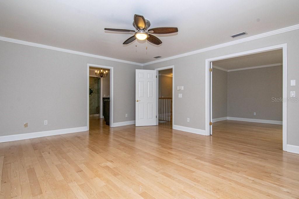 16405 Avila Boulevard Tampa, FL 33613 - Photo 26 of 61 a view of an empty room with wooden floor and a ceiling fan