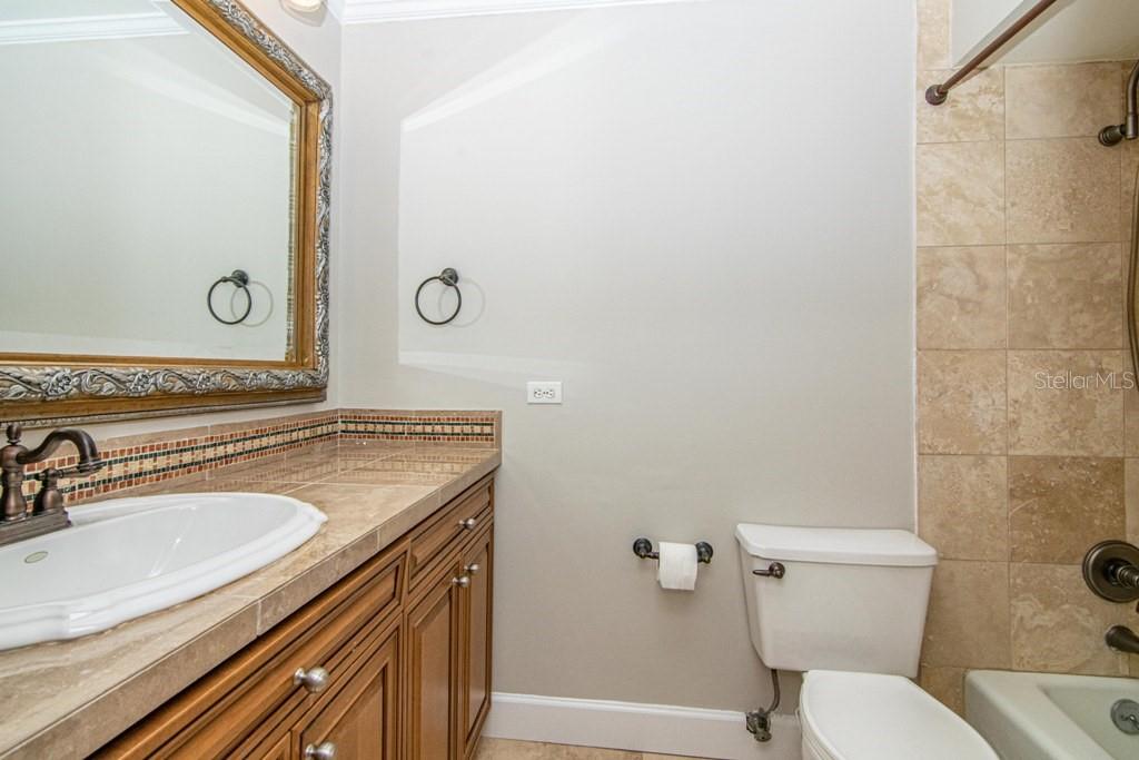 16405 Avila Boulevard Tampa, FL 33613 - Photo 38 of 61 a bathroom with a granite countertop toilet sink and mirror
