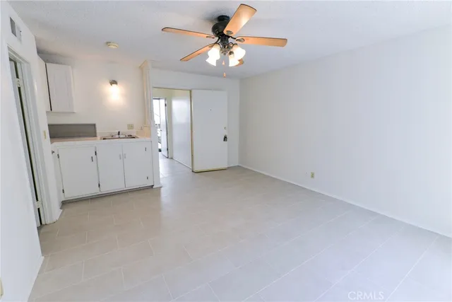 a view of a kitchen with a sink and a chandelier fan