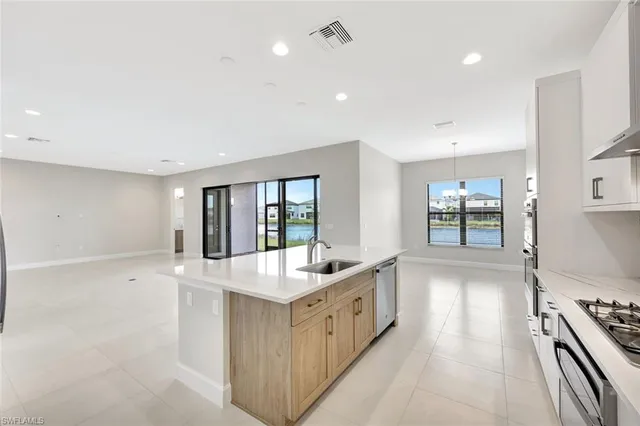 a kitchen with sink stove and refrigerator