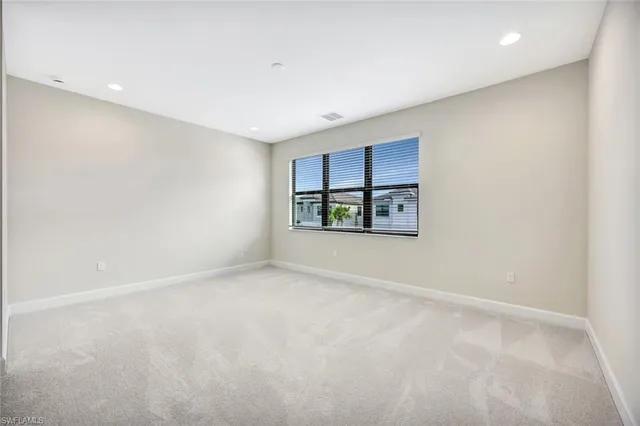 an empty room with windows and ceiling fan