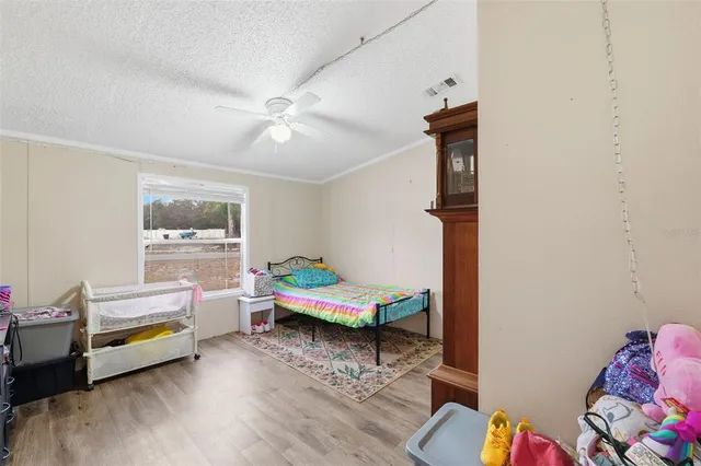 a bedroom with bed and wooden floor