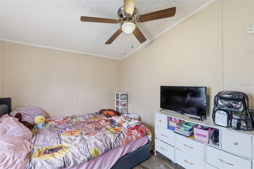 1890 Derosa Road Polk City, FL 33868 - Photo 17 of 20 a bedroom with a bed and a flat screen tv