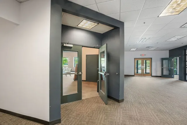 a view of a hallway with wooden floor and windows