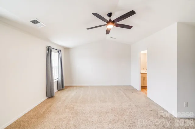 a view of a big room with wooden floor and a ceiling fan
