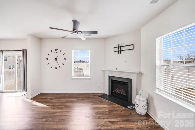 wooden floor fireplace and windows in an empty room