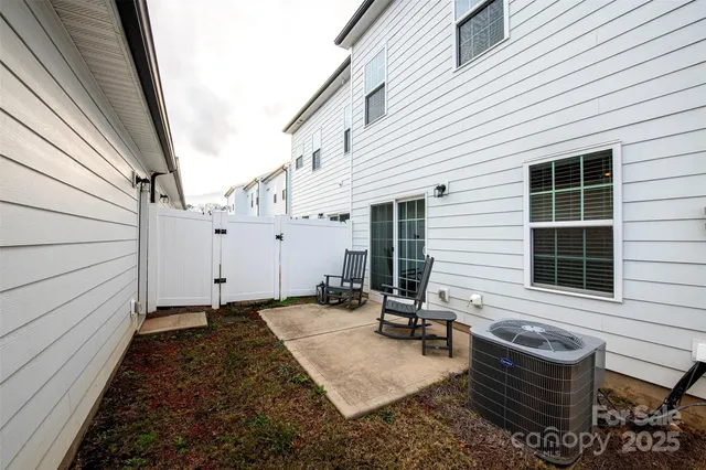 a view of a chair and table in backyard of the house