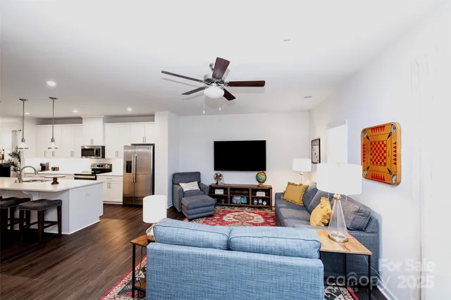 a living room with furniture kitchen view and a window