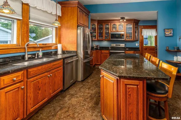 a kitchen with stainless steel appliances granite countertop a stove and large window