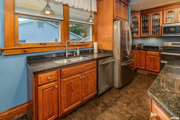 a kitchen with stainless steel appliances granite countertop a refrigerator and wooden cabinets