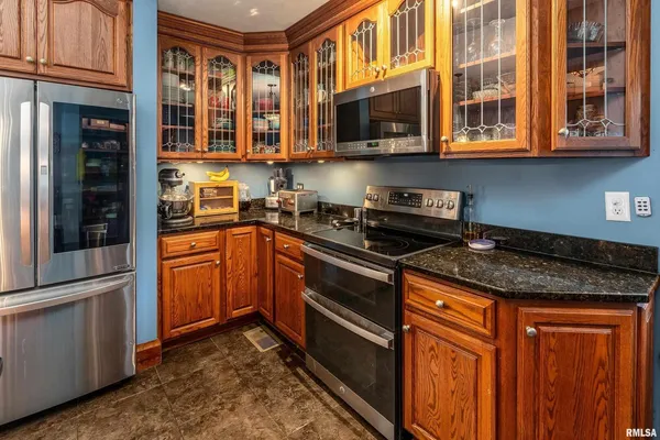a kitchen with stainless steel appliances granite countertop a stove microwave and cabinets