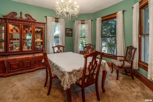 a dining room with furniture a chandelier and window
