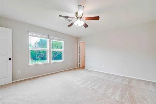 an empty room with a window and a fan