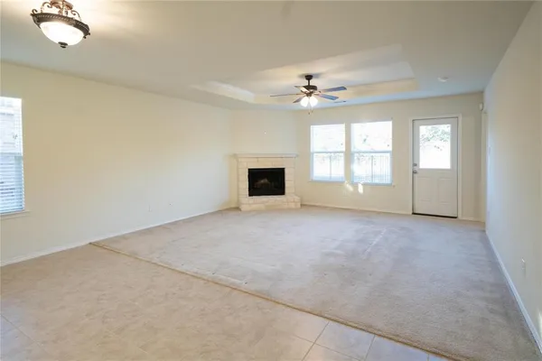 an empty room with windows and fireplace
