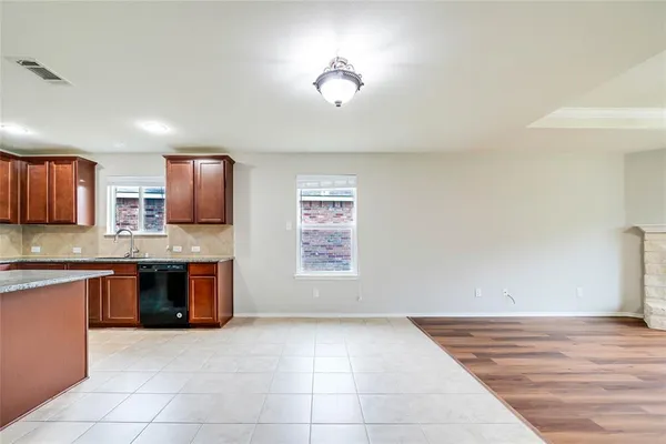 a large kitchen with granite countertop a stove top oven a sink dishwasher and a microwave oven on the blue kitchen countertops