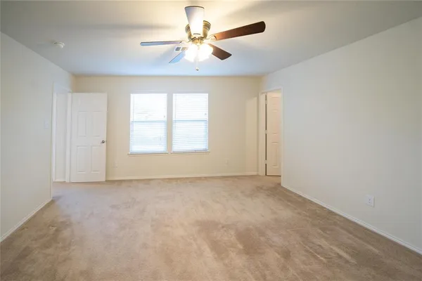 an empty room with windows and fan
