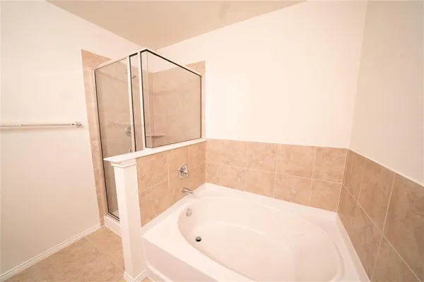 a bathroom with a white bath tub and shower