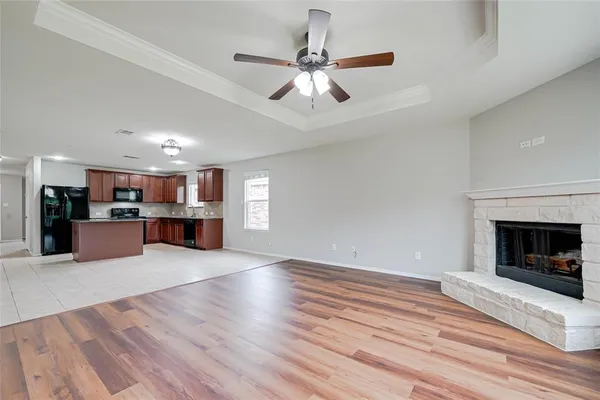 a view of kitchen and hall with wooden floor and a fireplace