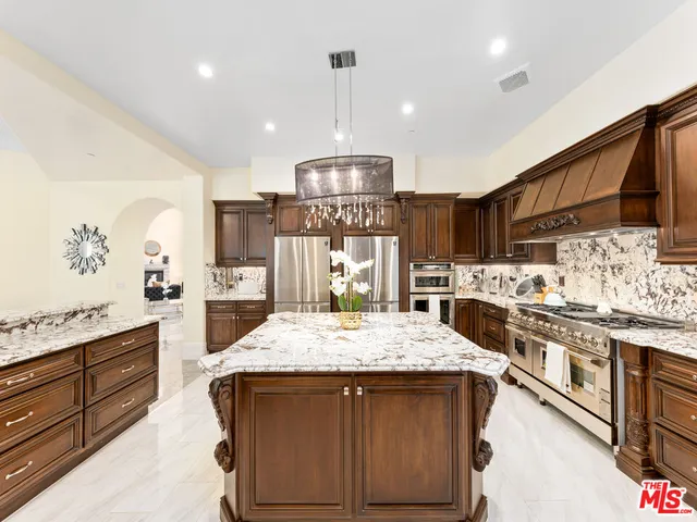 a kitchen with stainless steel appliances granite countertop a stove and cabinets