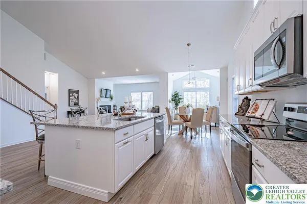 a kitchen with kitchen island granite countertop lots of counter top space and wooden floors