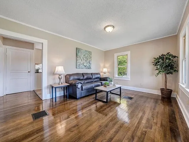 a living room with furniture and a wooden floor