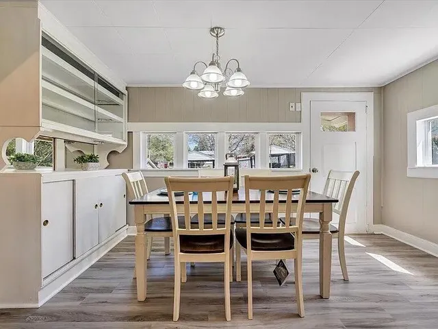 a view of a dining room with furniture a chandelier and wooden floor