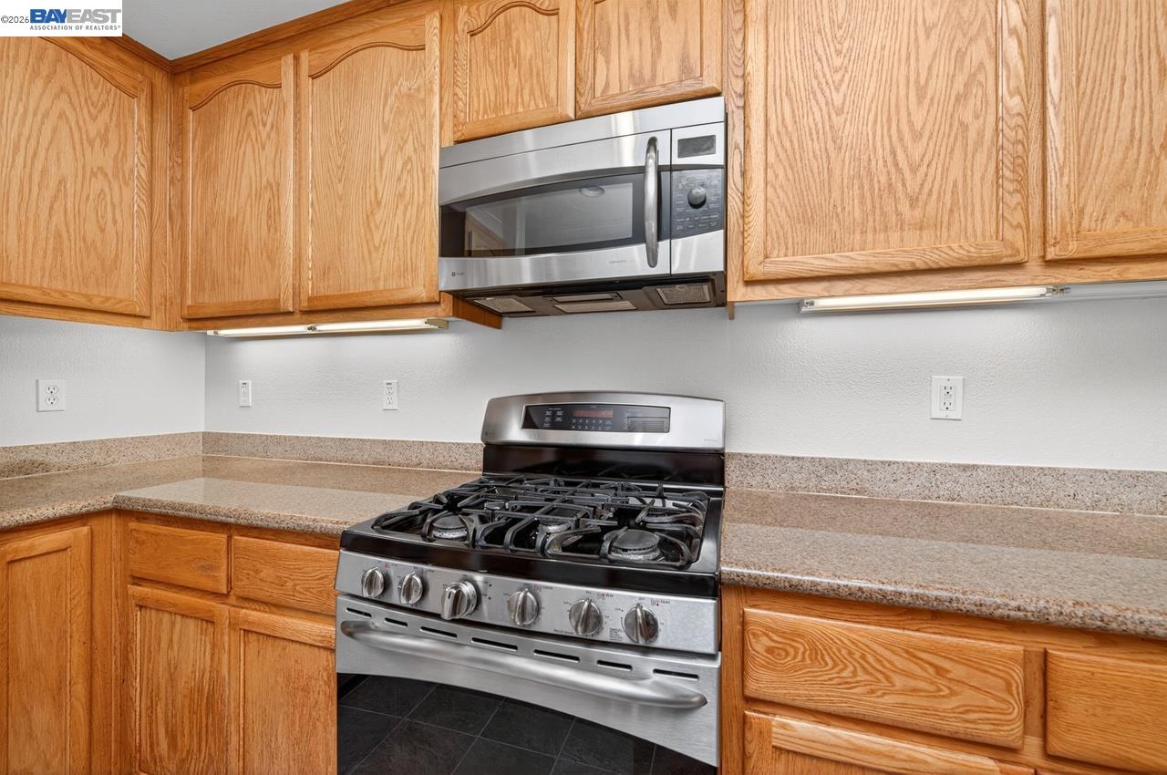 3391 Monaghan Street Dublin, CA 94568 - Photo 10 of 57 a kitchen with stainless steel appliances granite countertop white cabinets and a stove top oven