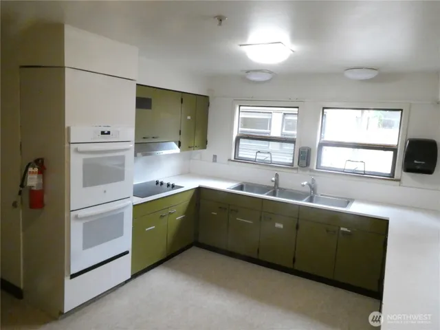 a kitchen with stainless steel appliances granite countertop a sink and cabinets with wooden floor