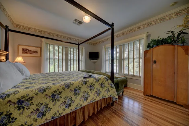 a bedroom with a bed dresser and a large window