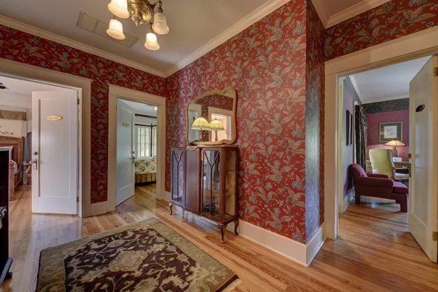 a view of a hallway with wooden floor and a chandelier