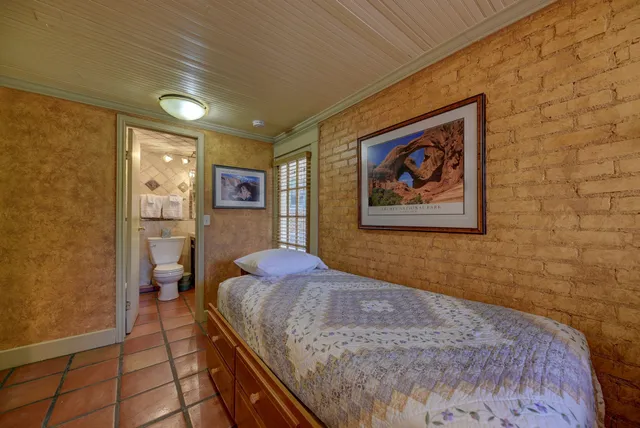 a bedroom with a large bed and a painting on the wall