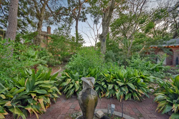 a backyard of a house with lots of green space and a fountain